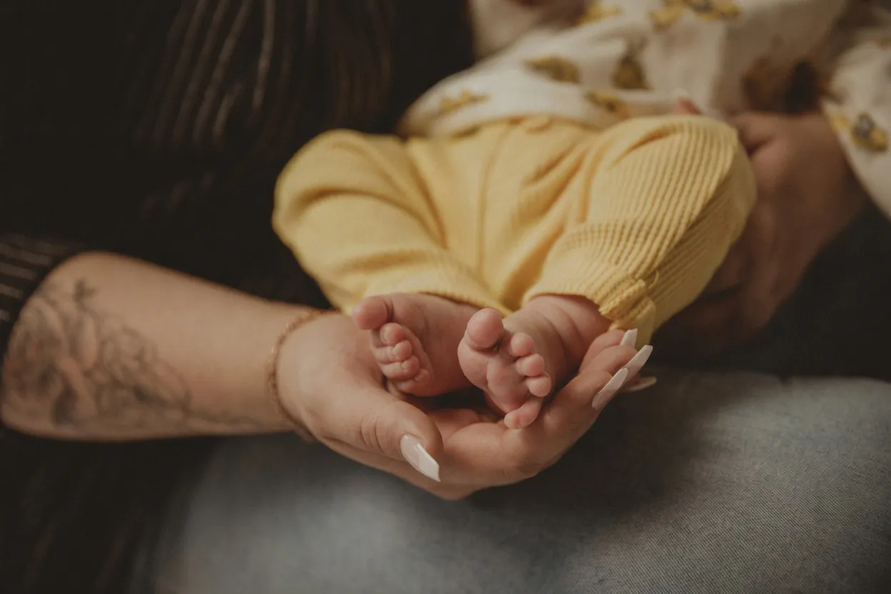 Winzige Babyfüße in gelbem Strampler – zarte Newborn-Fotografie aus Stade
